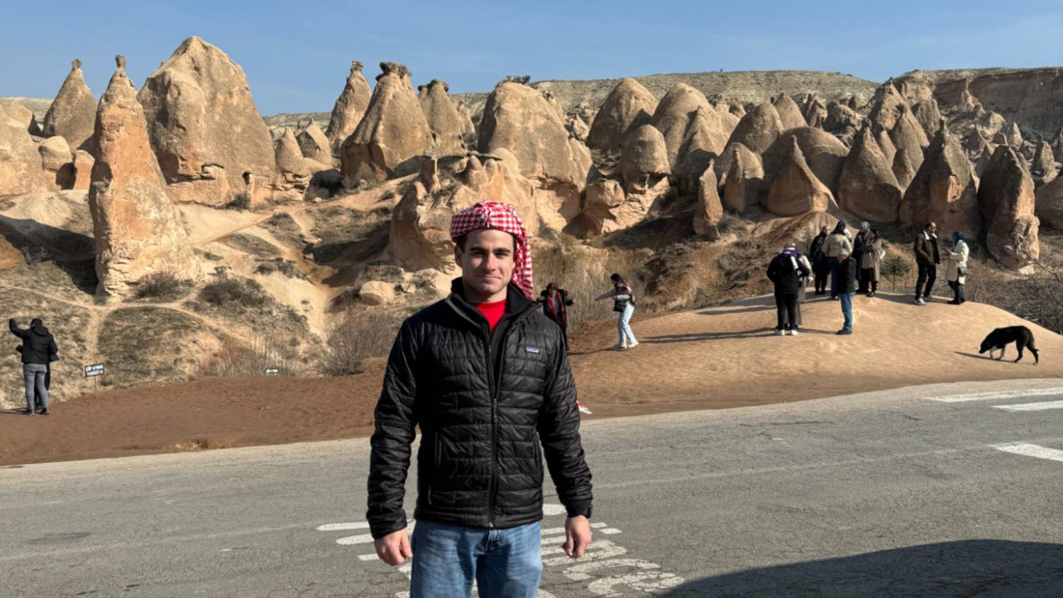 Eli stands in a scenic, rocky desert landscape.