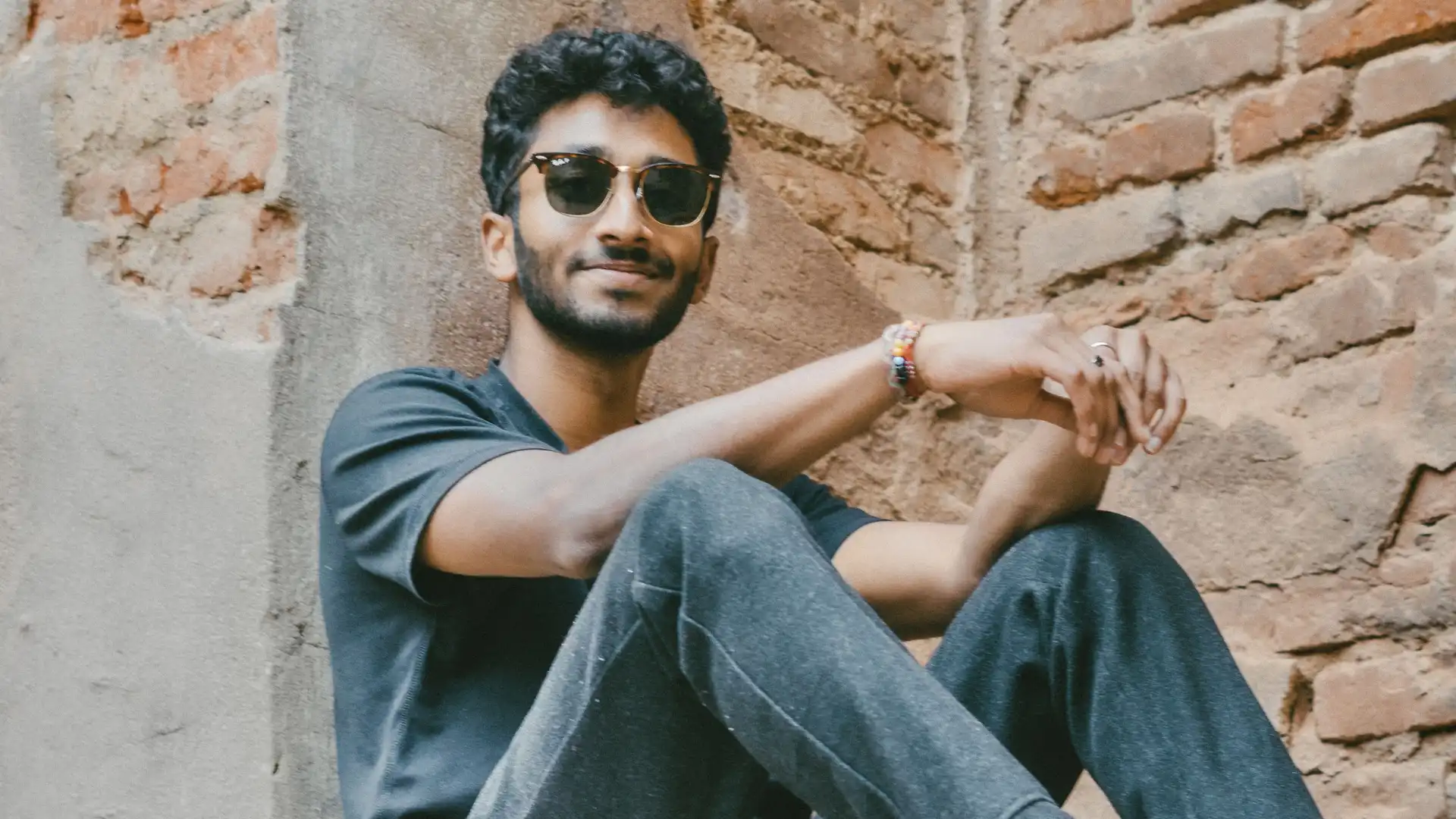 Close-up photo of Dillon Patel sitting at the foot of a church