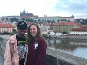 A student, Kaitlyn, with her friend at a bridge with Prague Castle in thebackground.