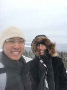 A student, Felix, with a friend in the mountains while it is windy and snowing.