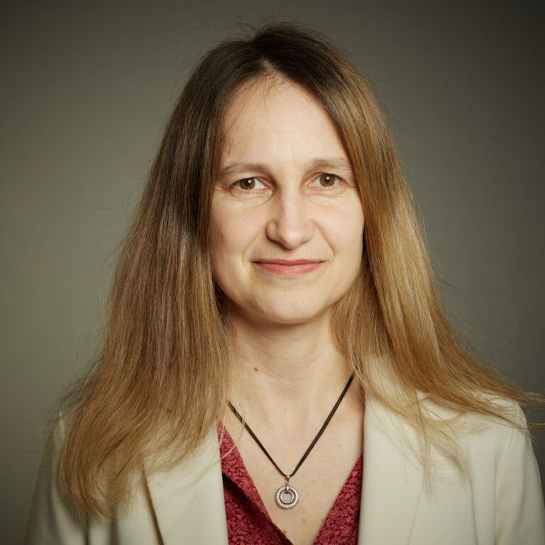 Indoor studio headshot of NC State Prague Faculty in World Literature, Blanka Maderová, on a simple gray background.
