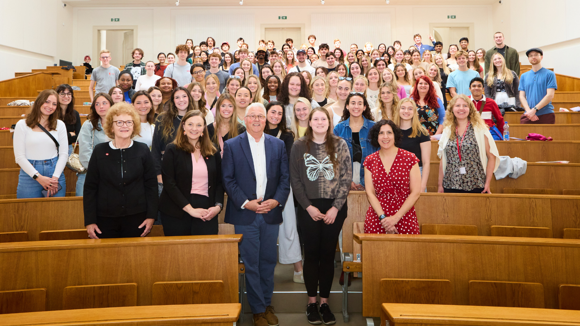 Group picture of over one hundred summer study abroad students and NC State Prague staff standing in the Prague Charles University largest lecture hall.