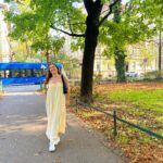 A student with long summer dress in a city park in Prague