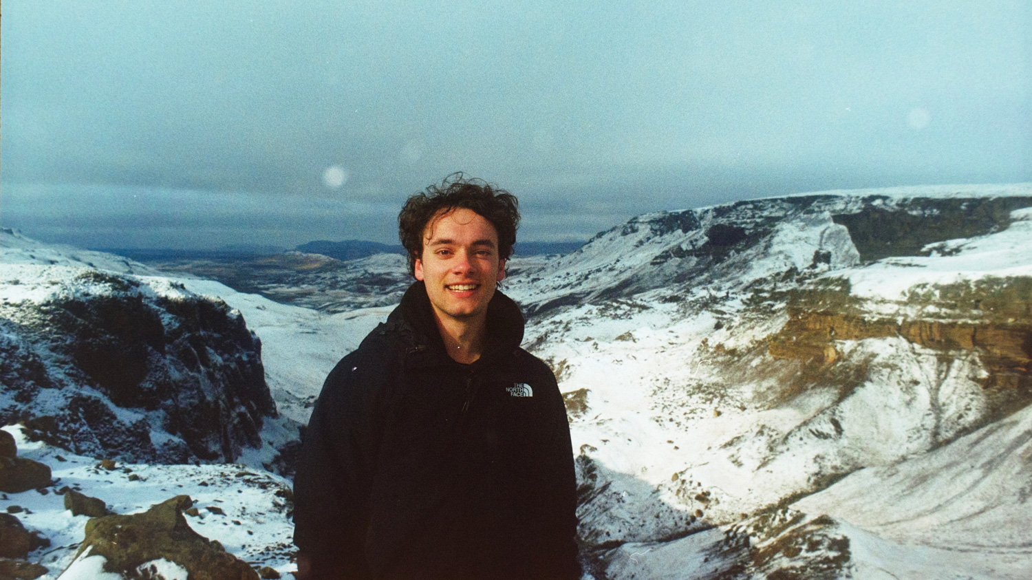 Student photo in Iceland, snowy hills in the background