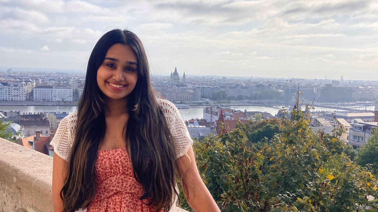 Aditi standing on a ledge above the city of Prague