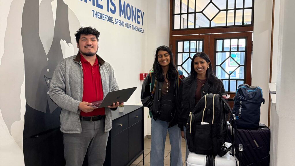 An intern helping two students check in to the student housing.