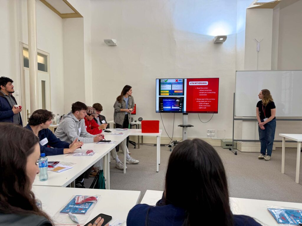 Students at their desk listing to a presentation on how to navigate Prague.